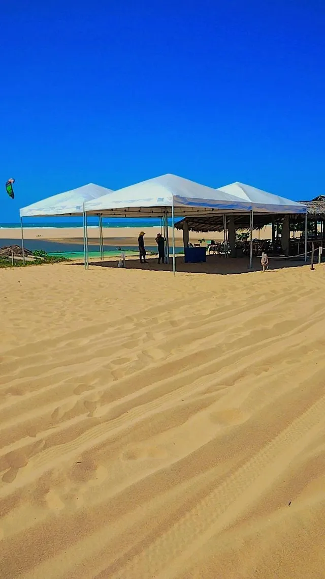 Tenda piramidal montada na areia à beira-mar