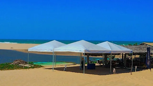 Aluguel de tenda para evento em duna, com lagoa e mar ao fundo